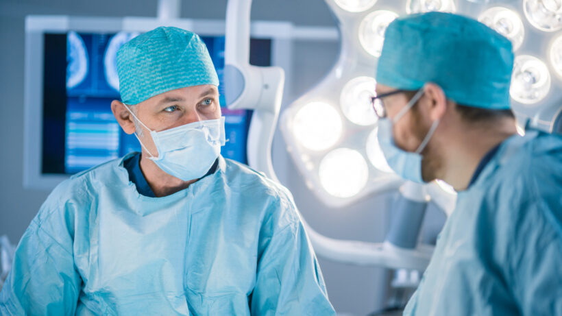 Two doctors performing surgery for artificial disc replacement surgery