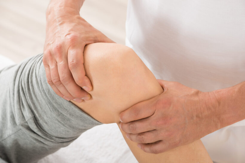 Close-up Of Therapist Hand Doing Knee Massage In Spa Saloon