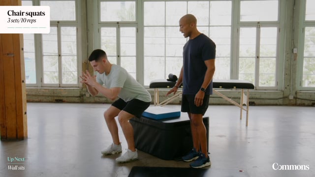 Man instructing patient in gym on squatting technique