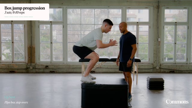 Patient in gym performing box squats while an instructor supervises