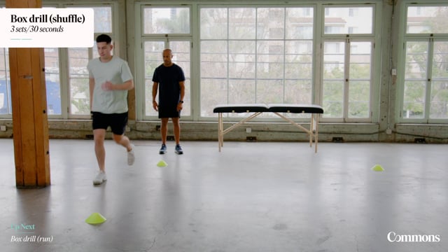 Patient in gym performs a running exercise while an instructor watches